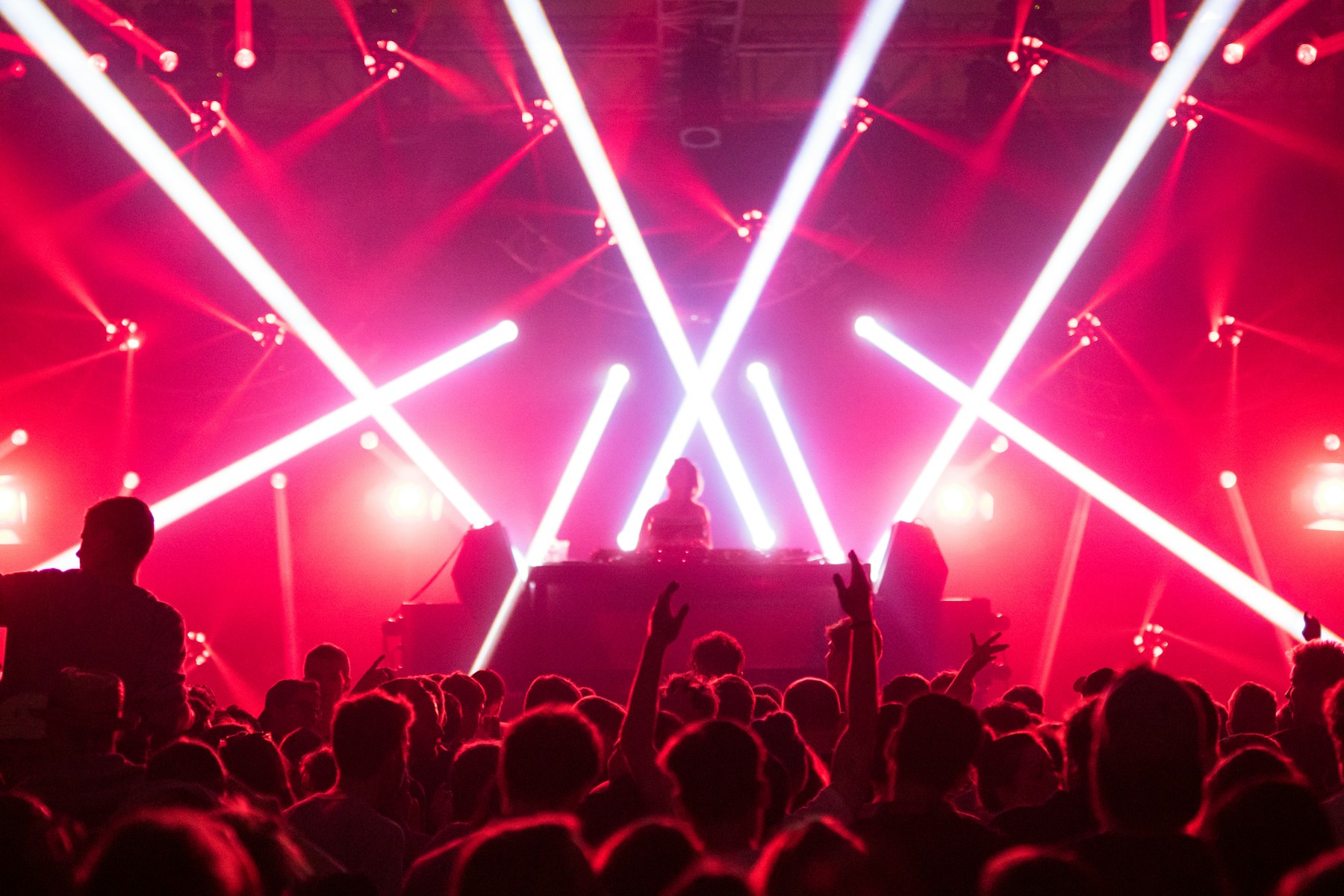 Il pubblico di un concerto sotto fasci di luce rossa